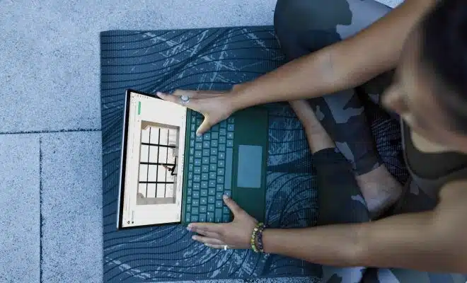 a woman using a laptop computer on a mat